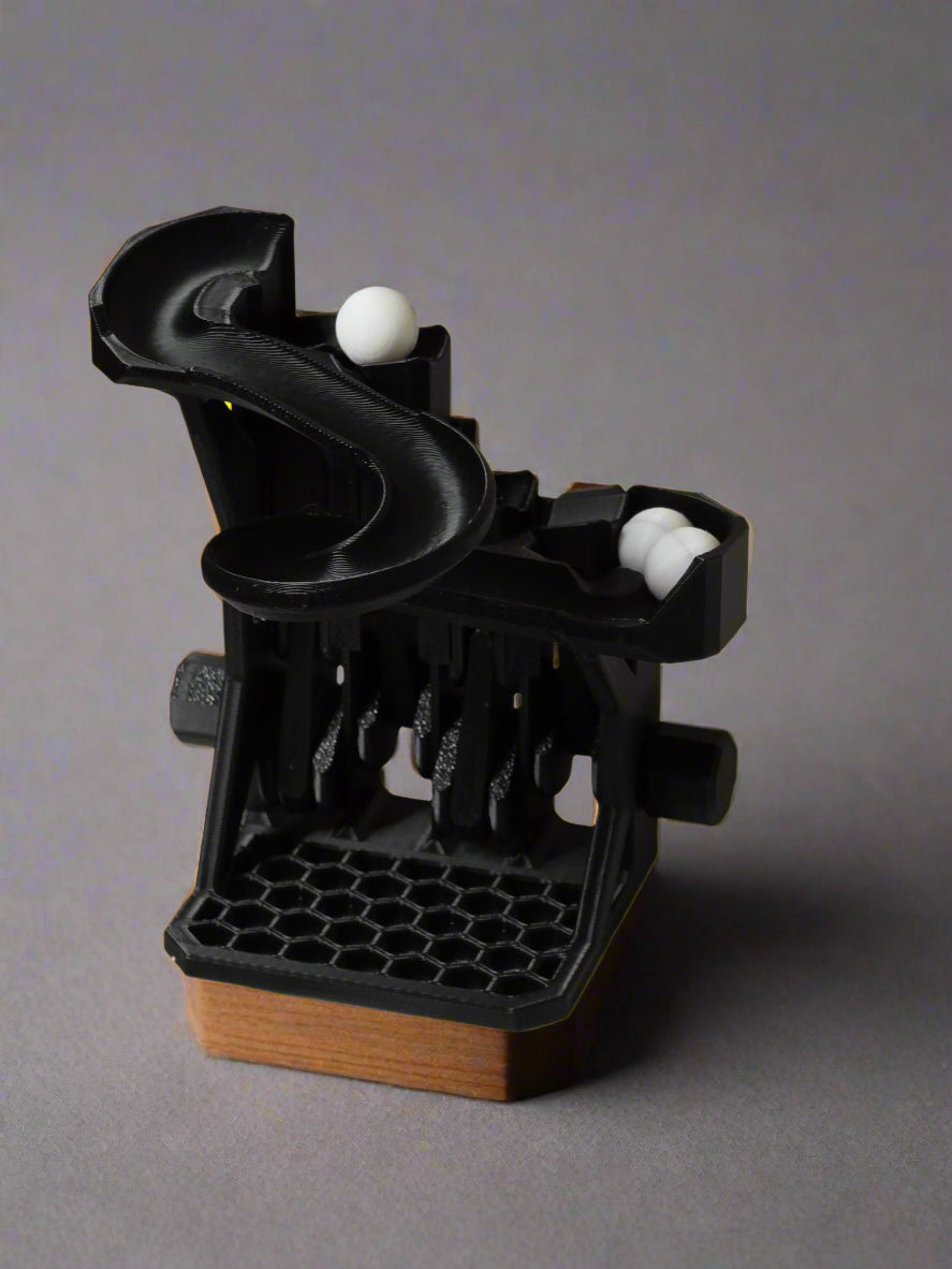 Black plastic device with white balls on a white surface